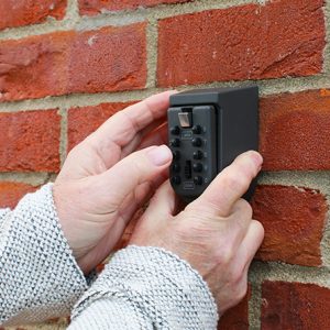 Elderly man using his outside security keysafe