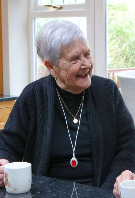 Two elderly people wearing their My Amie pendants